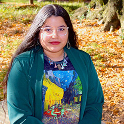 girl posing in front of fall landscaping