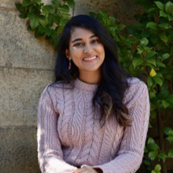 girl smiling beside concrete wall